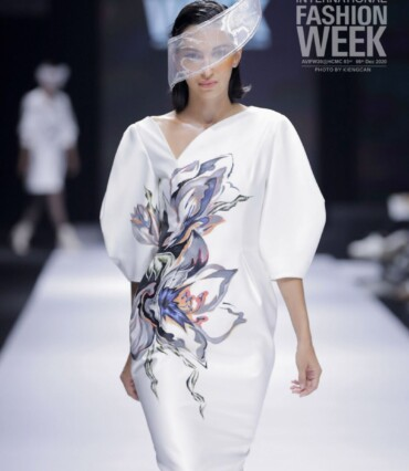 Model wearing an ivory dress with a painted floral motif